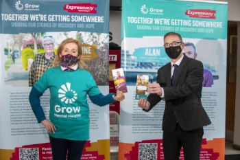 Image shows two people, Adrian O’Loughlin, Bus Éireann Operations Manager East and Grow representative Attracta McNeice in front of Grow Mental Health information boards 